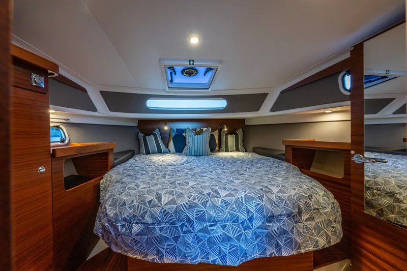 Slide: The Image of Luxurious cabin interior of 2024 Nimbus 365 Coupe with cozy bedding and ambient lighting. - 18