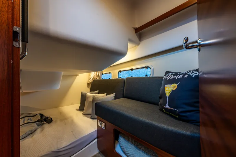 Slide: The Image of 2024 Nimbus 365 Coupe cabin interior with cozy seating and bedding. - 22