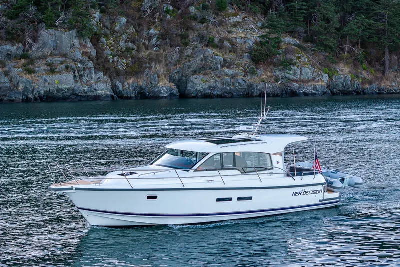 Slide: The Image of 2024 Nimbus 365 Coupe cruising on scenic waters near rocky shoreline. - 41