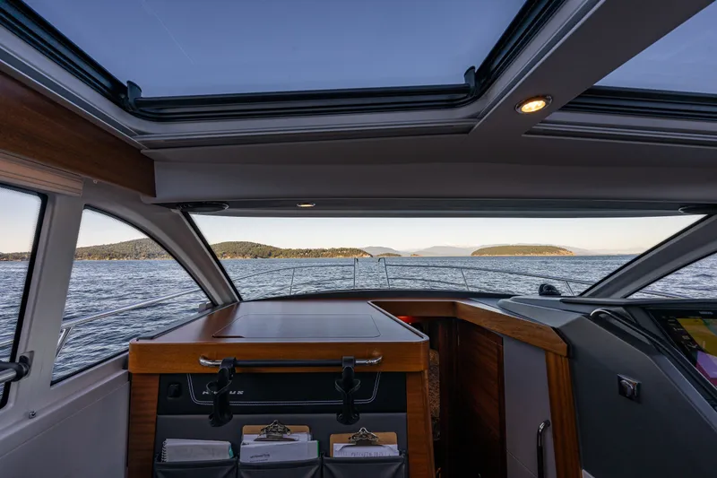 Slide: The Image of Interior view of 2024 Nimbus 365 Coupe yacht with ocean and island scenery. - 16