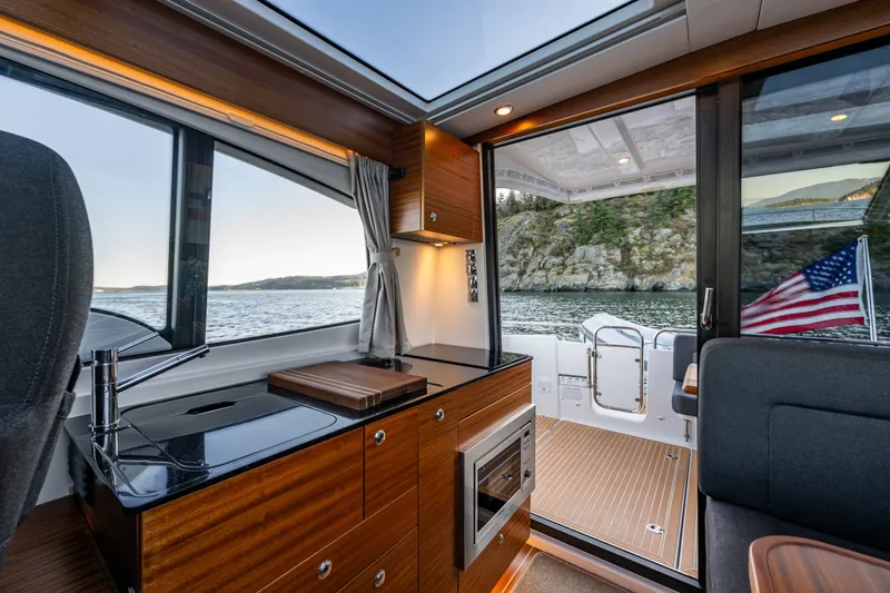 Slide: The Image of Interior of 2024 Nimbus 365 Coupe yacht with sleek kitchen and scenic water view. - 9