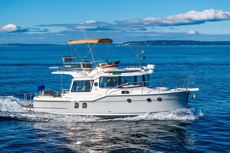 Slide: The Image of 2023 Ranger Tugs R-29 CB cruising on open blue water under clear skies. - 53