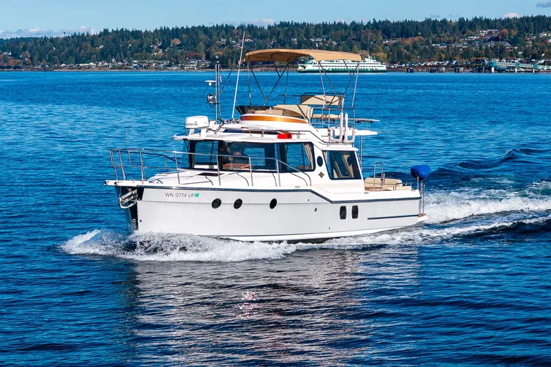 Slide: The Image of 2023 Ranger Tugs R-29 CB cruising on a scenic blue lake. - 48
