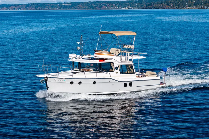 Slide: The Image of 2023 Ranger Tugs R-29 CB cruising on a serene blue lake. - 49