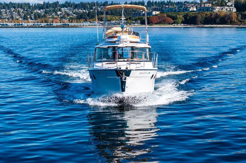 Slide: The Image of 2023 Ranger Tugs R-29 CB cruising on a scenic lake with vibrant shoreline. - 47