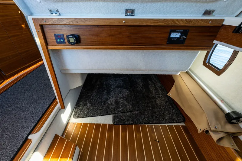 Slide: The Image of 2023 Ranger Tugs R-29 CB interior cabin with wood paneling and control panel. - 18