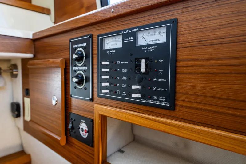 Slide: The Image of Control panel of 2023 Ranger Tugs R-29 CB boat, featuring wood finish and electrical gauges. - 19