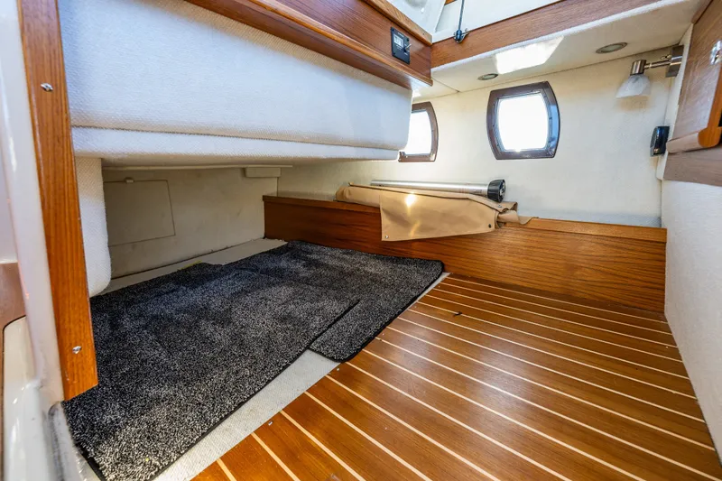 Slide: The Image of 2023 Ranger Tugs R-29 CB interior cabin with wood flooring and cozy sleeping area. - 17