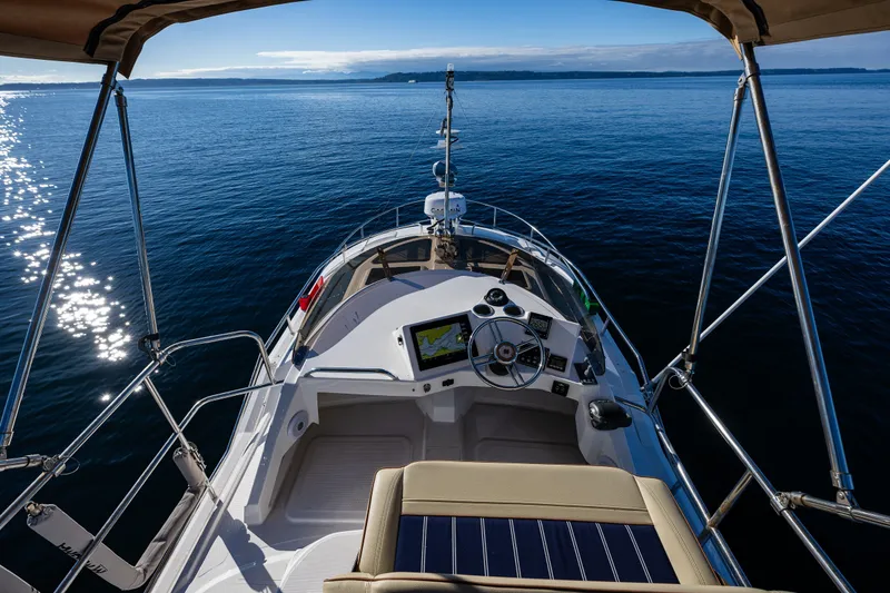 Slide: The Image of 2023 Ranger Tugs R-29 CB helm view on open water, sunny day. - 24