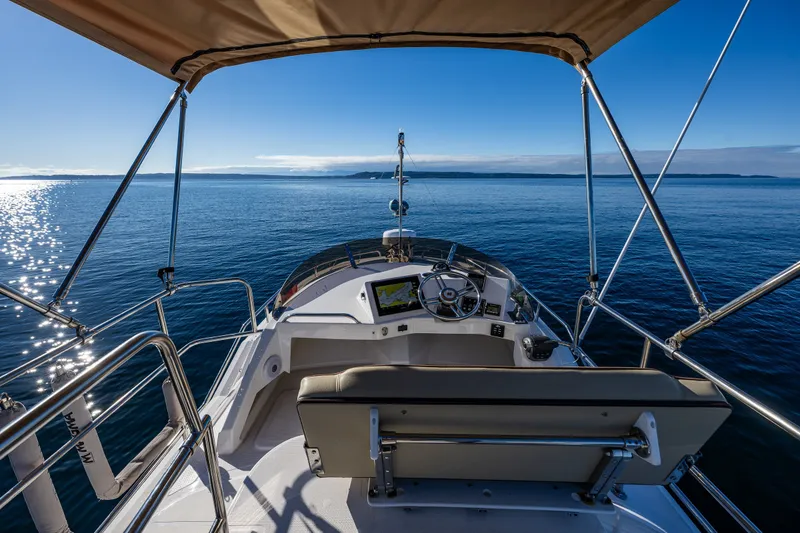 Slide: The Image of 2023 Ranger Tugs R-29 CB helm view on open water under clear blue sky. - 25