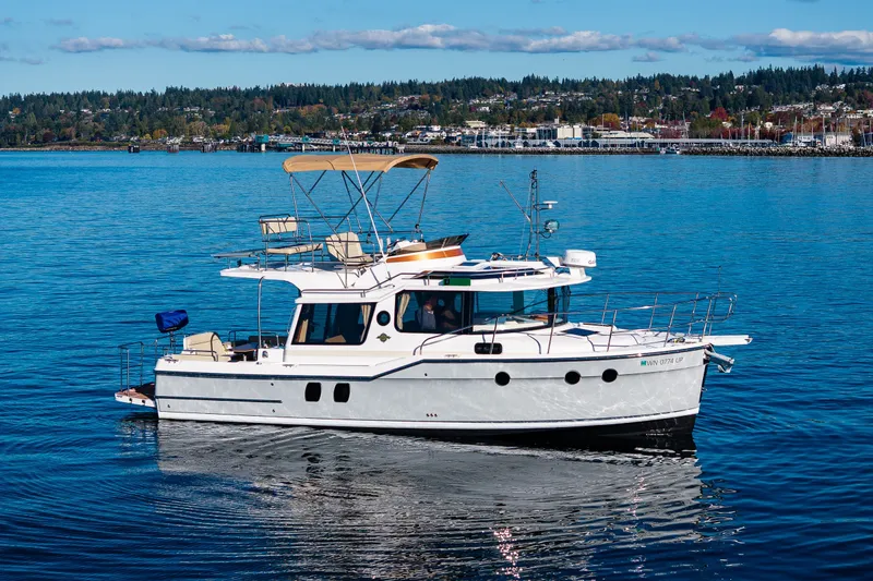 Slide: The Image of 2023 Ranger Tugs R-29 CB cruising on a serene lake with scenic background. - 37