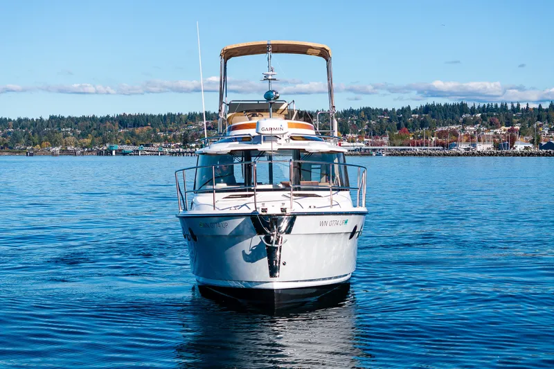 Slide: The Image of 2023 Ranger Tugs R-29 CB boat on calm water with scenic shoreline background. - 36