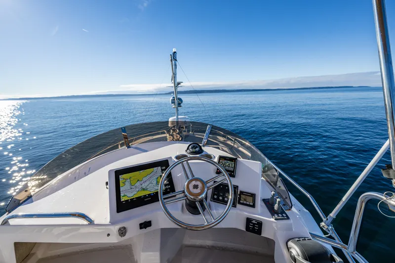 Slide: The Image of Helm of 2023 Ranger Tugs R-29 CB boat with navigation equipment, steering wheel, and ocean view. - 23