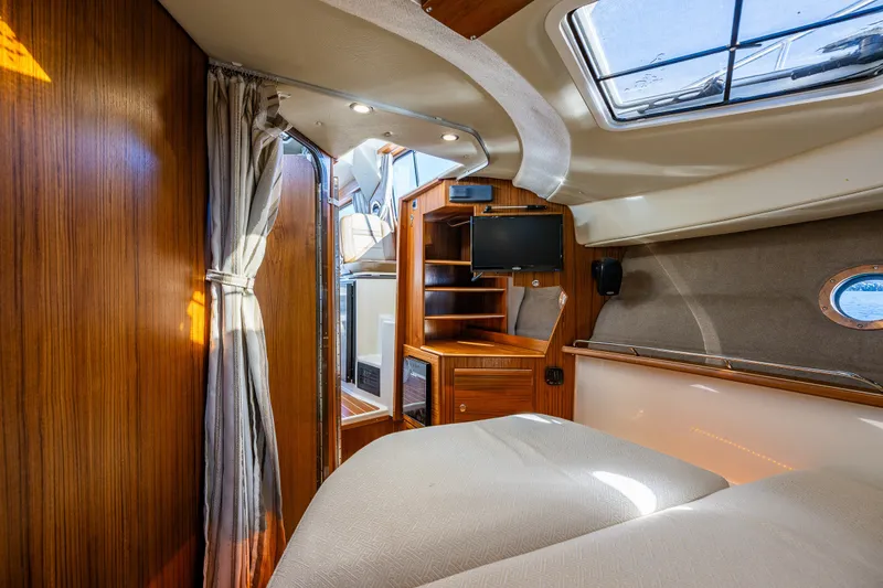 Slide: The Image of 2023 Ranger Tugs R-29 CB cabin interior with wood paneling and modern amenities. - 14