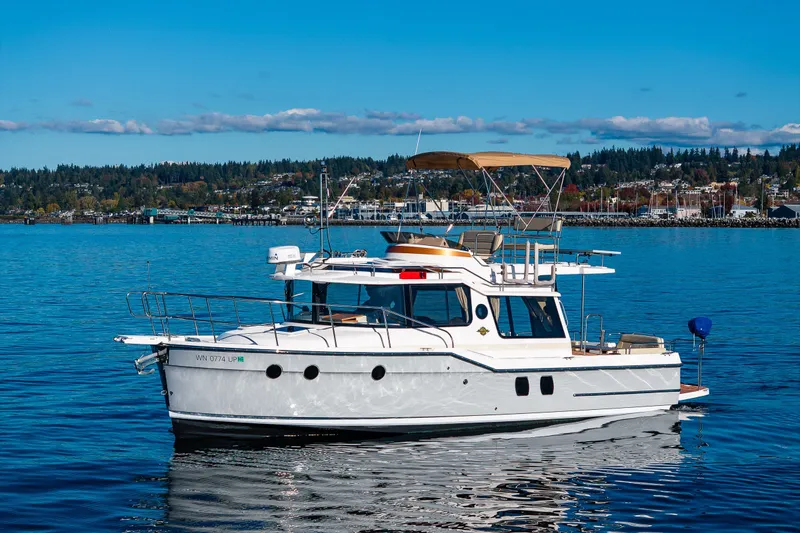 Slide: The Image of 2023 Ranger Tugs R-29 CB boat on calm water with scenic shoreline background. - 35