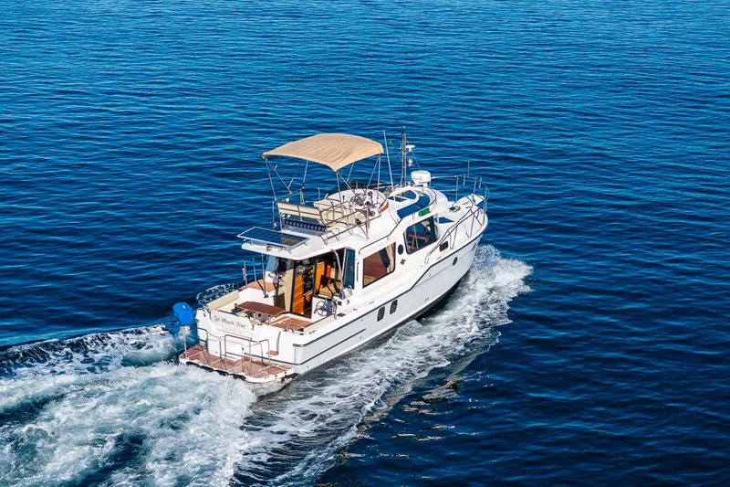 Slide: The Image of 2023 Ranger Tugs R-29 CB cruising on open water, showcasing sleek design and spacious deck. - 55
