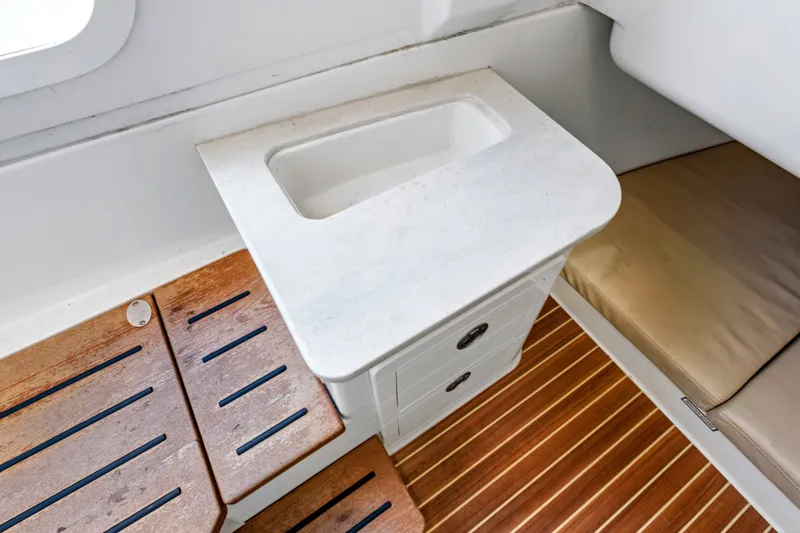 Slide: The Image of Interior of 2019 Sailfish 360 CC boat featuring a compact sink and wooden flooring. - 36