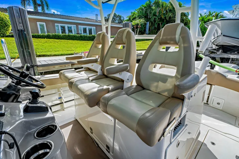 Slide: The Image of 2019 Sailfish 360 CC boat interior with three cushioned seats and steering console. - 13