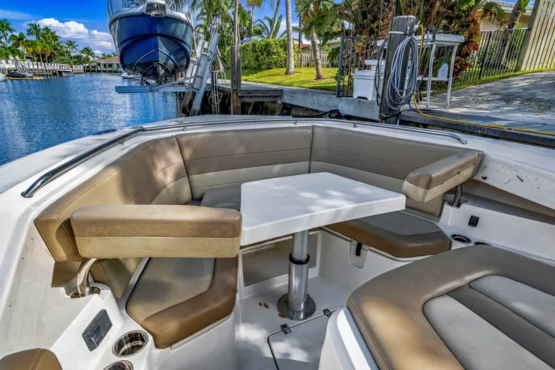 Slide: The Image of 2019 Sailfish 360 CC boat interior with cushioned seating and table by the water. - 27