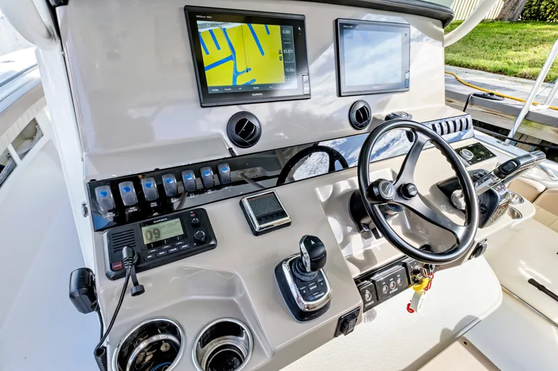 Slide: The Image of 2019 Sailfish 360 CC boat dashboard with navigation screens and steering wheel. - 29
