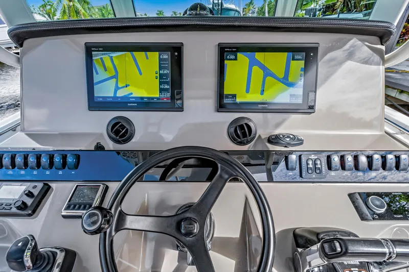 Slide: The Image of 2019 Sailfish 360 CC boat dashboard with dual Garmin navigation screens and steering wheel. - 28