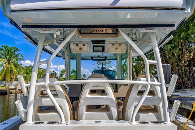 Slide: The Image of 2019 Sailfish 360 CC boat interior with Garmin electronics, docked near tropical foliage. - 25