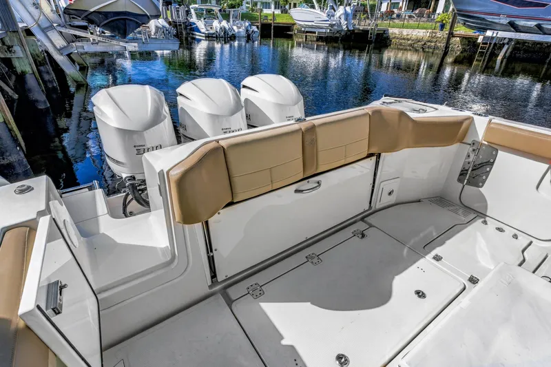 Slide: The Image of 2019 Sailfish 360 CC boat with triple Yamaha engines docked by the water. - 16