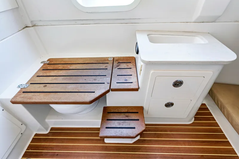 Slide: The Image of 2019 Sailfish 360 CC boat interior with wooden seat, sink, and striped flooring. - 34