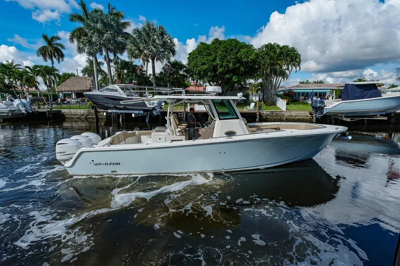The Image of 2019 Sailfish 360 CC boat cruising on a sunny day near a tropical shoreline. - 0