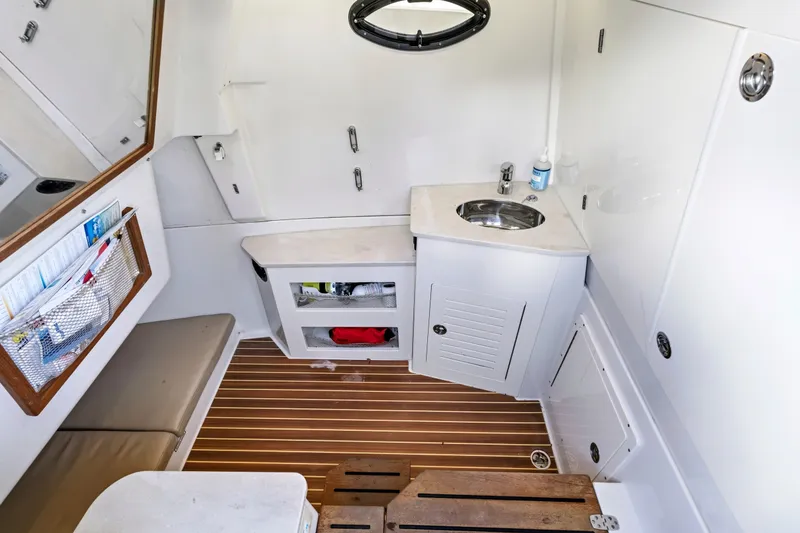 Slide: The Image of 2019 Sailfish 360 CC cabin interior with sink, storage, and wooden flooring. - 39