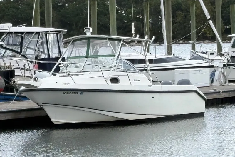 Slide: The Image of Boston Whaler 235 Conquest 1998 boat docked at marina, surrounded by other vessels. - 3