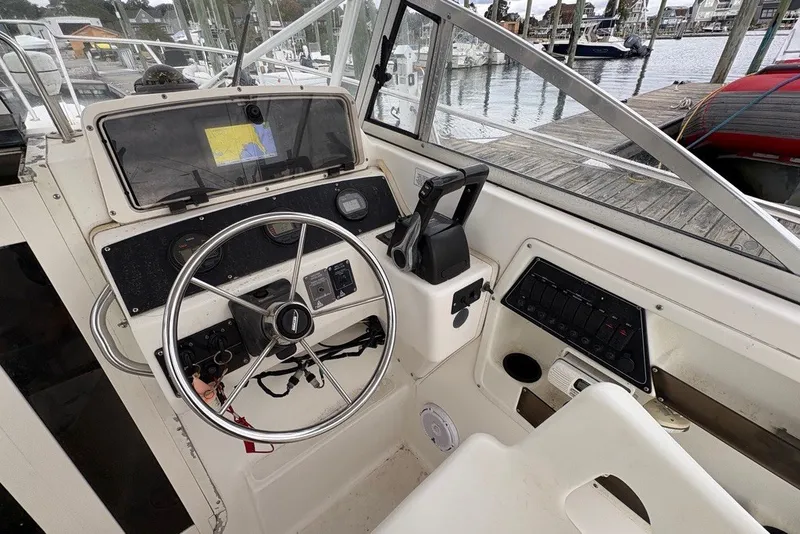Slide: The Image of 1998 Boston Whaler 235 Conquest helm with steering wheel and navigation equipment. - 9