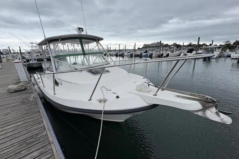 Slide: The Image of 1998 Boston Whaler 235 Conquest docked at marina under cloudy skies. - 4