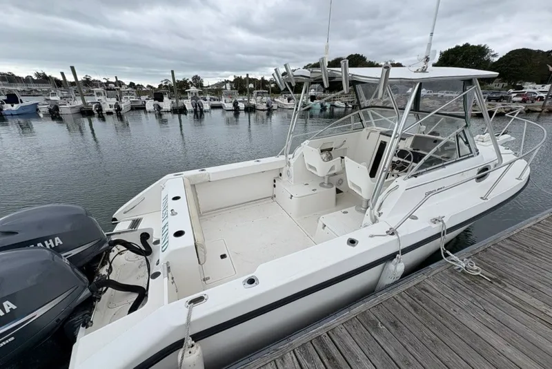 Slide: The Image of 1998 Boston Whaler 235 Conquest docked, featuring dual Yamaha engines and spacious cockpit. - 8