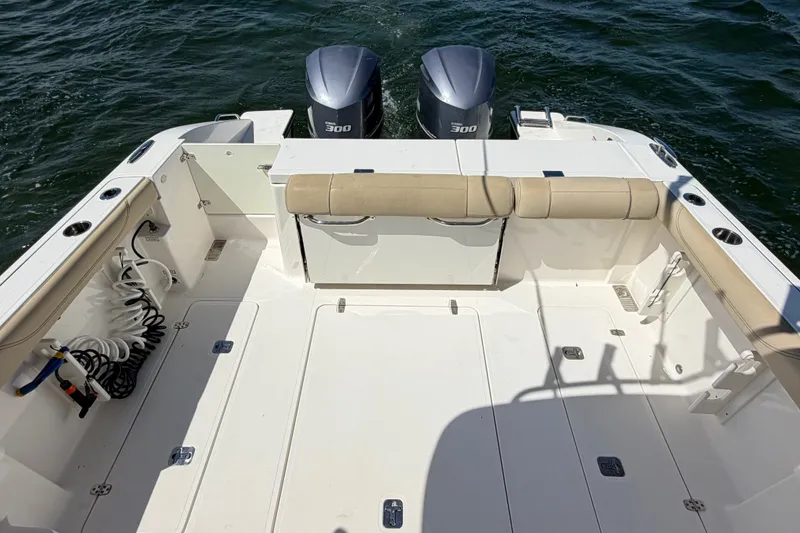 Slide: The Image of 2017 Pursuit OS 325 Offshore boat deck with twin 300 engines on water. - 10