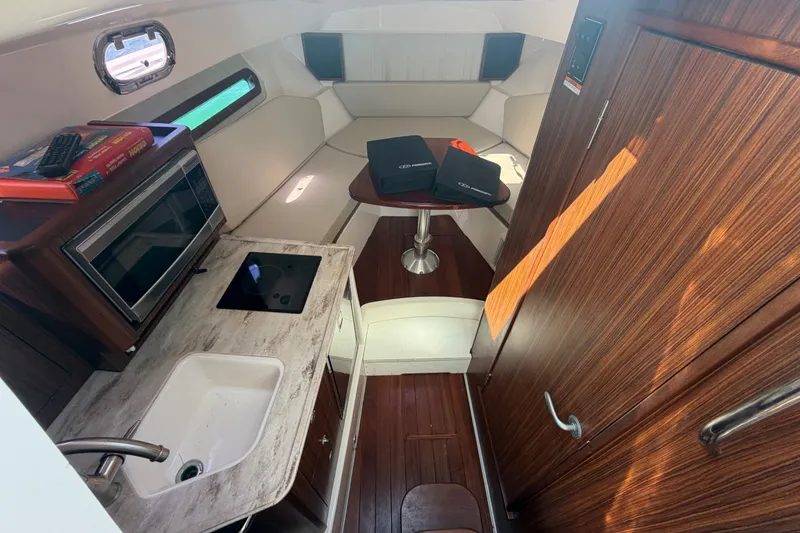 Slide: The Image of Interior of 2017 Pursuit OS 325 Offshore boat with kitchenette and seating area. - 34