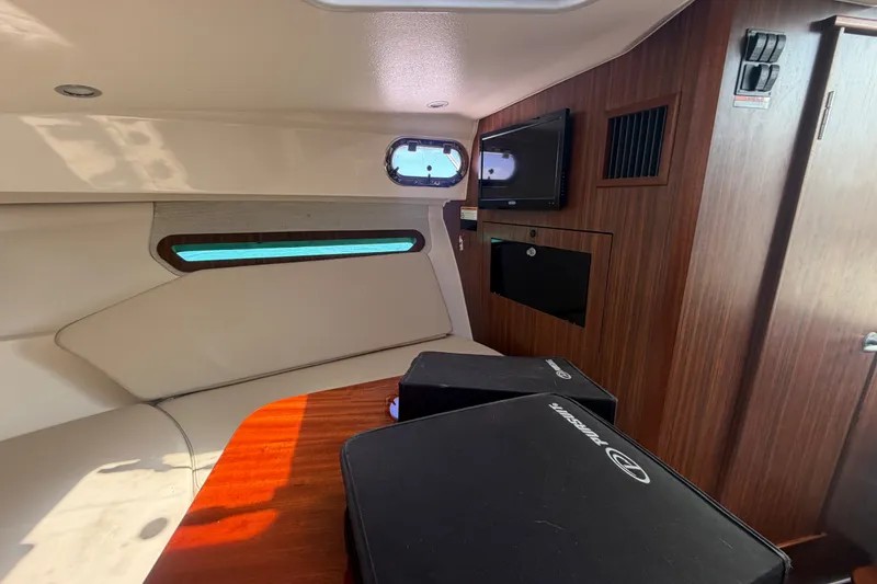Slide: The Image of Interior of a 2017 Pursuit OS 325 Offshore boat with wood paneling and a small window. - 46
