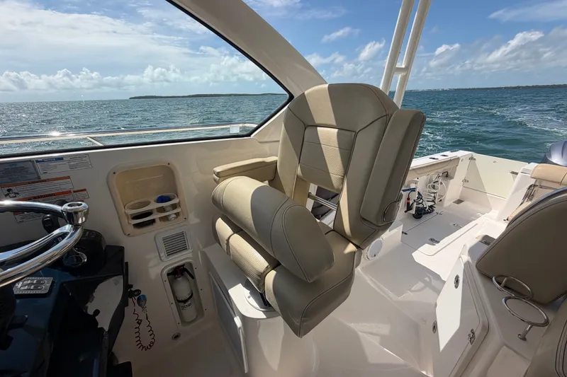 Slide: The Image of 2017 Pursuit OS 325 Offshore boat interior with helm seat and ocean view. - 25