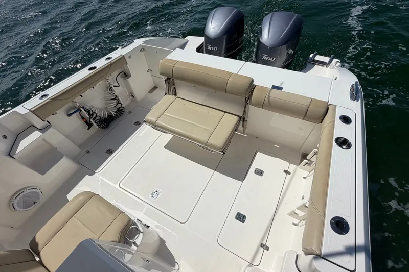 Slide: The Image of 2017 Pursuit OS 325 Offshore boat deck with seating and twin engines on the water. - 12