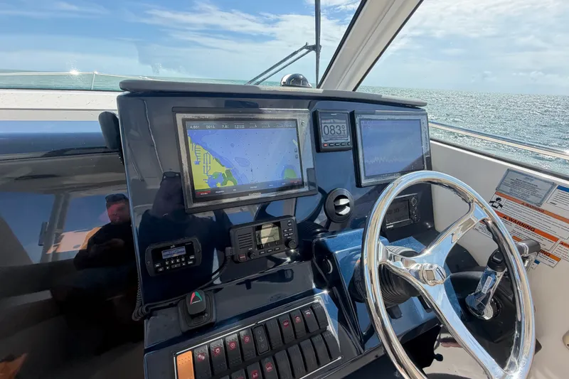 Slide: The Image of Helm of 2017 Pursuit OS 325 Offshore boat with navigation screens and steering wheel. - 28