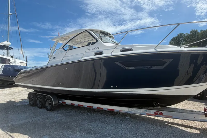 Slide: The Image of 2017 Pursuit OS 325 Offshore boat on trailer under clear blue sky. - 9