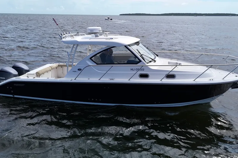 Slide: The Image of 2017 Pursuit OS 325 Offshore boat cruising on open water. - 4