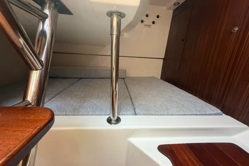 Slide: The Image of 2017 Pursuit OS 325 Offshore cabin interior with wooden accents and cushioned seating. - 44