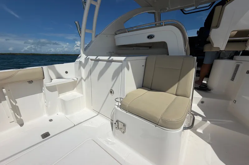 Slide: The Image of 2017 Pursuit OS 325 Offshore boat interior with beige seating and ocean view. - 17