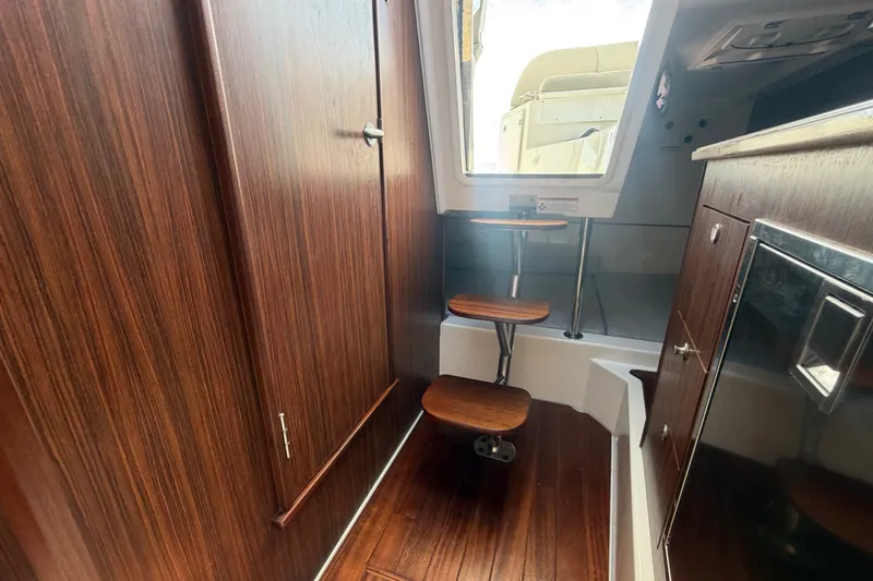 Slide: The Image of Interior of 2017 Pursuit OS 325 Offshore boat with wooden steps and cabinetry. - 45