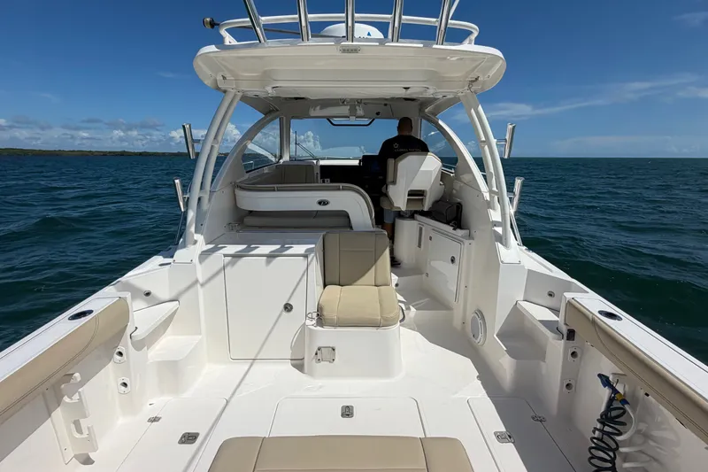 Slide: The Image of 2017 Pursuit OS 325 Offshore boat on open water, featuring spacious deck and seating. - 16