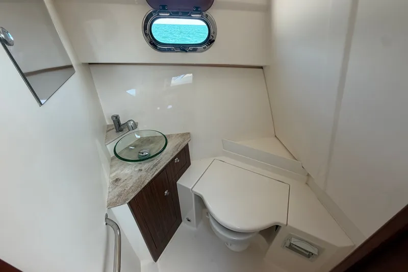 Slide: The Image of 2017 Pursuit OS 325 Offshore boat bathroom with modern sink and compact toilet. - 38
