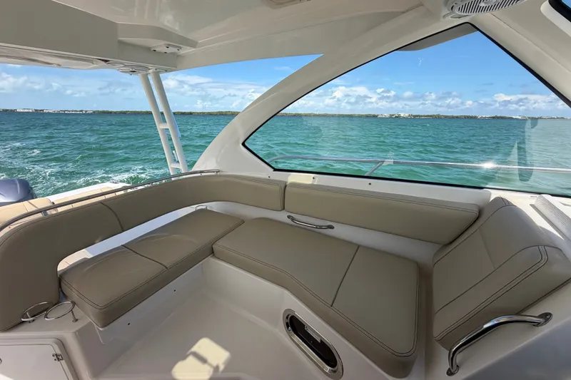 Slide: The Image of 2017 Pursuit OS 325 Offshore boat interior with beige seating, overlooking calm blue waters. - 33