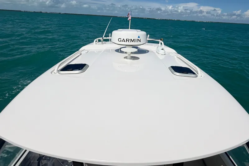 Slide: The Image of 2017 Pursuit OS 325 Offshore boat on turquoise water, featuring Garmin equipment. - 52