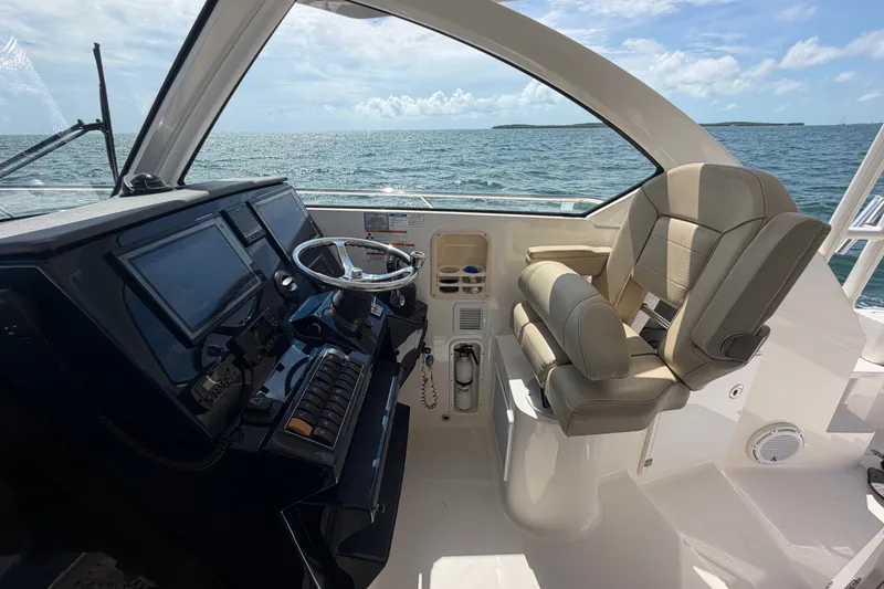 Slide: The Image of 2017 Pursuit OS 325 Offshore helm with modern controls and ocean view. - 24